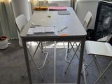 une table et des chaises blanches dans une pièce dotée d'une fenêtre