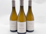 trois bouteilles de vin posées sur une table blanche