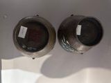 two silver vases on display in a glass case
