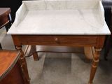 a marble top table with a drawer underneath it