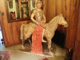 a statue of a woman riding a horse in a room