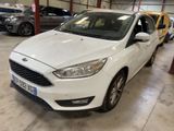 the white ford focus is parked in a garage with other cars