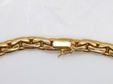 a close up of a gold bracelet on a white surface