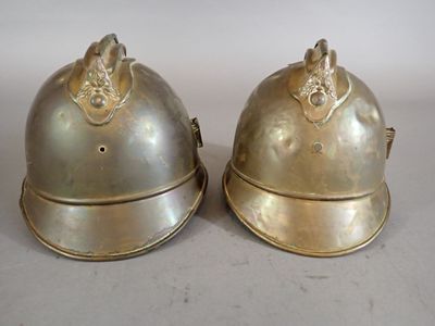 pair of antique brass helmets with lion heads on them