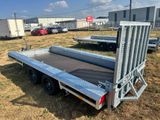 the flatbed trailer is parked on the grass in the field