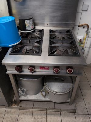 a blue bucket sitting on top of a stove in a kitchen