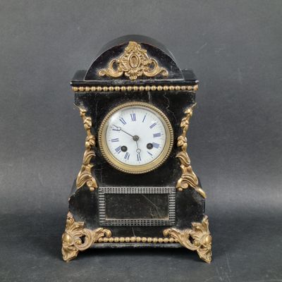 a black and gold clock with roman numerals on it