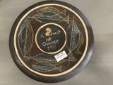 a black and gold plate with a picture of a hawk on it