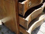 une commode en bois surmontée de trois tiroirs
