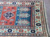 a close up of a rug on a floor with a blue and red design