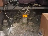 de nombreux verres vides posés sur une étagère dans une pièce