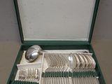 un coffret vert contenant de l'argenterie sur une table