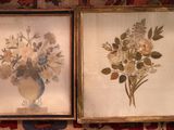deux photos encadrées représentant des fleurs dans un vase posées sur un tapis