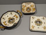 trois pièces de poterie exposées sur une table dans une pièce