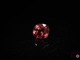 a close up of a red diamond on a black surface