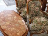 several chairs and a table in a room with a lot of furniture