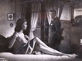 une photo en noir et blanc d'une femme assise sur un lit à côté d'un homme