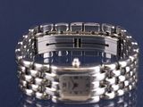an image of a silver bracelet watch on a blue surface