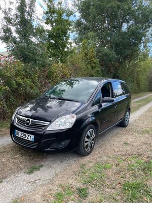 a black van parked on the side of a dirt road