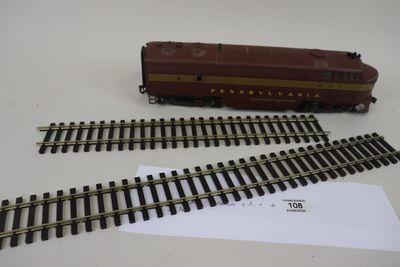un petit train sur les rails, à côté d'une feuille de papier