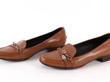 a pair of women ' s brown loafers with a metal buckle