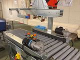 un tapis roulant dans une usine, sur lequel se trouve une machine