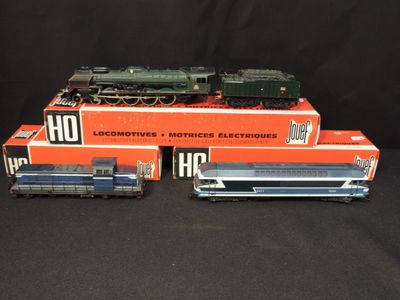 three toy trains sitting on top of each other on a black surface