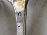 a silver spoon with a heart on it sitting on a table