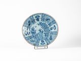 assiette bleue et blanche posée sur un support, sur fond blanc