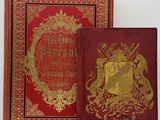 deux livres rouges ornés de dorures, posés l'un à côté de l'autre