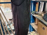 une photo d'un homme debout dans un entrepôt avec une planche de surf