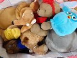 many stuffed animals in a basket on a table