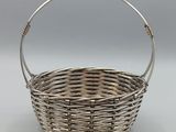a silver plated basket with a handle