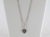 collier en argent avec un pendentif en forme de cœur sur un mannequin blanc