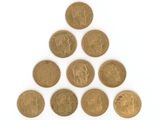 un tas de pièces d'or disposées en pyramide sur une surface blanche
