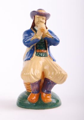 a figurine of a man sitting on a green base