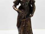 statue en bronze représentant une femme tenant une harpe et une flûte