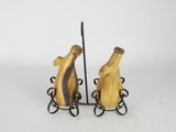 two wooden birds on a wire stand on a white background