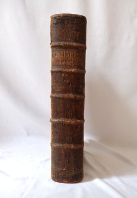 un vieux livre posé sur une table blanche, devant un fond blanc
