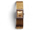 un gros plan d'une montre en or sertie de diamants sur fond blanc