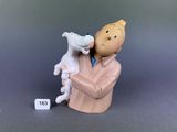 une figurine représentant un homme tenant un mouton