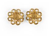 a pair of gold earrings with filigree details