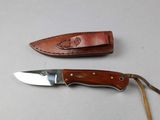 a knife that is laying on a table next to another knife