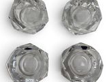 four clear glass ashtrays on a white surface with one ashtray in the middle