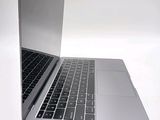a silver laptop with a black keyboard on a white surface