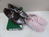two pairs of pink and silver tennis shoes on a table