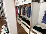a mirror in the corner of a room with clothes on it