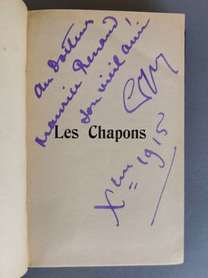 un livre ouvert, sur lequel figurent des inscriptions en violet, posé sur une table