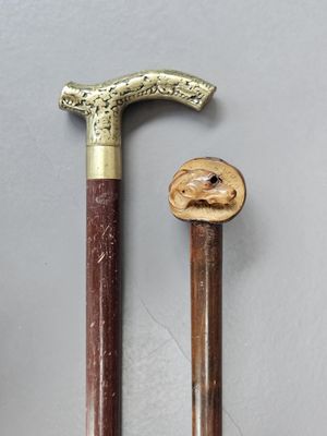 two old canes with a wooden handle sitting next to each other on a table