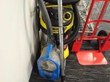 a vacuum that is sitting on the floor next to a red cart